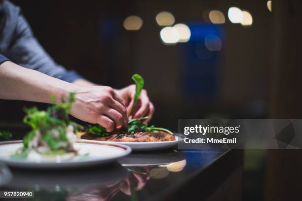 koch bereitet vielen platten in einer restaurantküche. catering. lebensmittelindustrie - menü stock-fotos und bilder