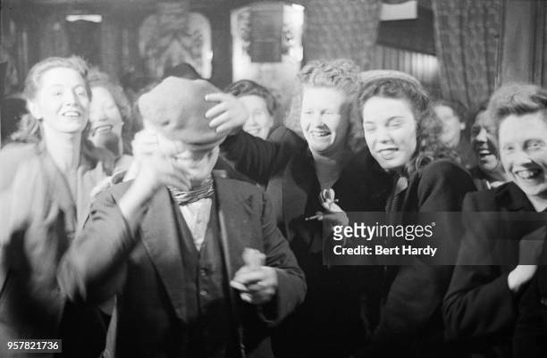 Frivolous approach to a game of darts is taken by patrons of The Crown public house, on Blackfriars Road, London, during celebrations of the wedding...