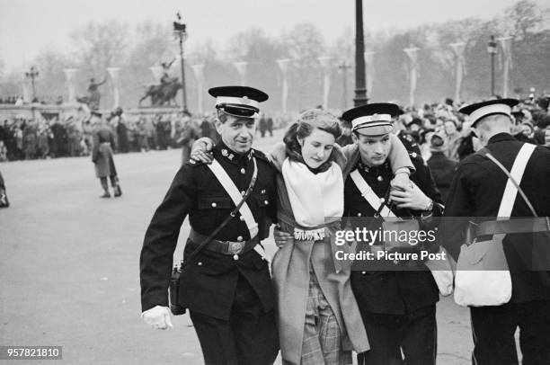 Casualty is assisted by volunteers of the St John Ambulance outside Buckingham Palace in London during the wedding of Princess Elizabeth and Philip...