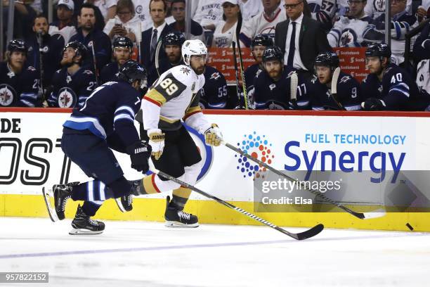 Alex Tuch of the Vegas Golden Knights is defended by Ben Chiarot of the Winnipeg Jets during the first period in Game One of the Western Conference...