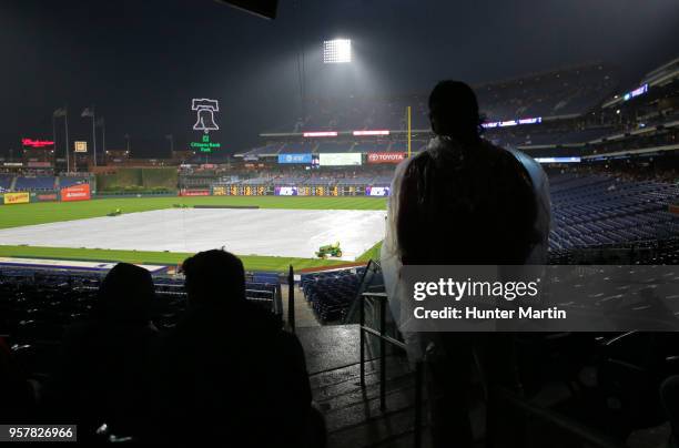 An usher stands under an overhang during a rain delay before a game between the Philadelphia Phillies and the New York Mets at Citizens Bank Park on...