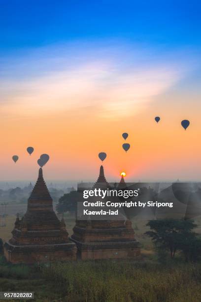 air balloons are floating over the bagan pagodas at sunrise, old bagan, myanmar. - copyright by siripong kaewla iad stock pictures, royalty-free photos & images