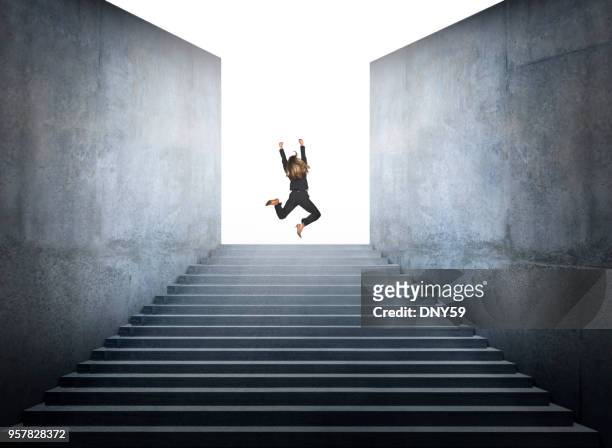 businesswoman jumps for joy at the top of steps - leap forward stock pictures, royalty-free photos & images