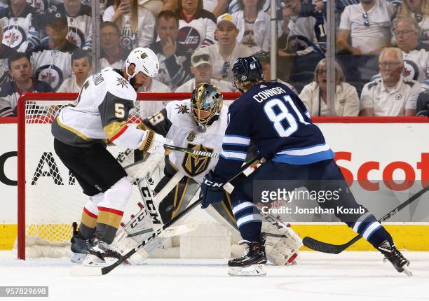 Deryk Engelland, Goaltender Marc-Andre Fleury of the Vegas Golden Knights and Kyle Connor of the Winnipeg Jets eye the puck during first period...