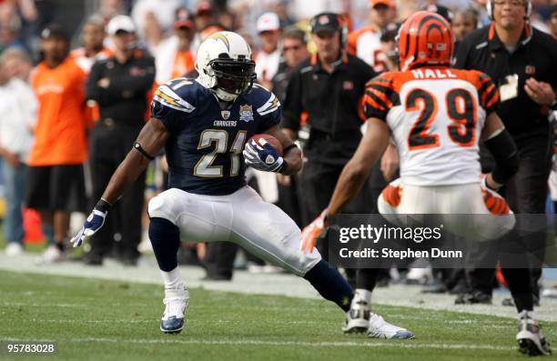 Running back LaDainian Tomlinson#21 of the San Diego Chargers carries the ball against defensive back Leon Hall of the Cincinnati Bengals on December...