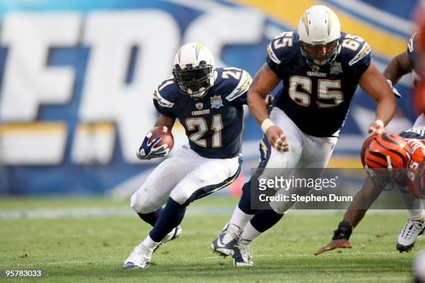 Running back LaDainian Tomlinson#21 of the San Diego Chargers carries the ball behind the block of tckle Jeromey Clary the Cincinnati Bengals on...