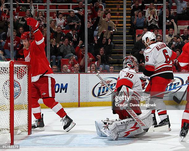 Dan Cleary of the Detroit Red Wings celebrates after his assist on goal while Cam Ward of the Carolina Hurricanes and teammate Tim Gleason look on...