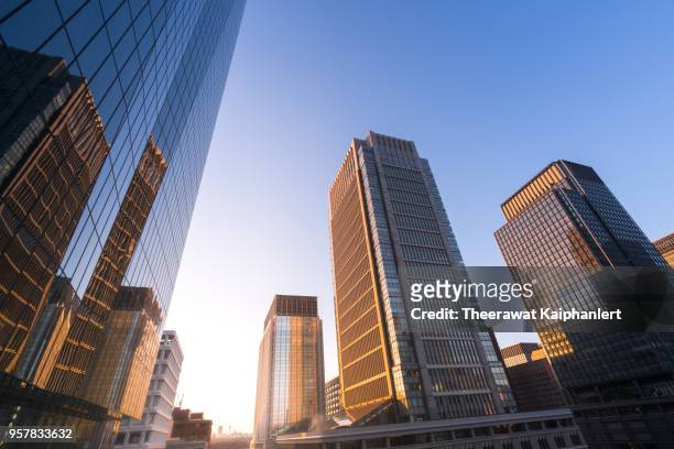 low angle view of skyscrapers in tokyo downtown in the morning - tokyo skyline sunset foto e immagini stock