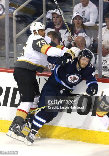 Joel Armia of the Winnipeg Jets is checked into the boards by Ryan Reaves of the Vegas Golden Knights during the second period in Game One of the...