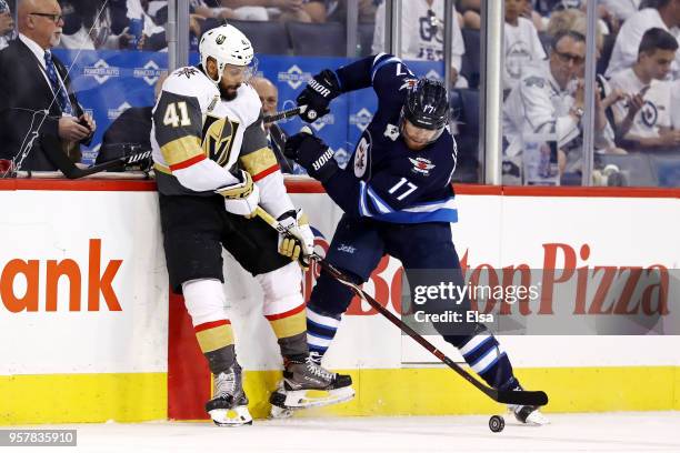 Pierre-Edouard Bellemare of the Vegas Golden Knights and Adam Lowry of the Winnipeg Jets battle for the puck during the second period in Game One of...