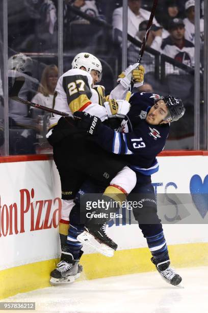 Shea Theodore of the Vegas Golden Knights and Brandon Tanev of the Winnipeg Jets collide during the second period in Game One of the Western...