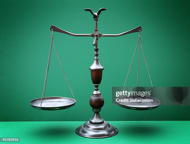 the scales of justice against a green background - scales of justice stock pictures, royalty-free photos & images