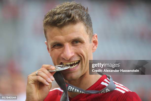 Thomas Mueller of Bayern Muenchen lifts the trophy in Celebration for winning the German Champiosnhip title after the Bundesliga match between FC...