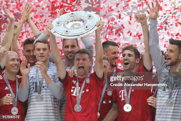 Thomas Mueller of Bayern Muenchen lifts the trophy in Celebration for winning the German Champiosnhip title after the Bundesliga match between FC...