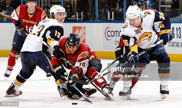 Marty Reasoner of the Atlanta Thrashers battles for the puck against Tim Kennedy and Patrick Kaleta of the Buffalo Sabres at Philips Arena on January...