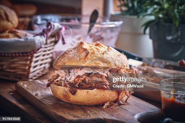 rommelig getrokken varkensvlees hamburger met koolsla - bbq sandwich stockfoto's en -beelden