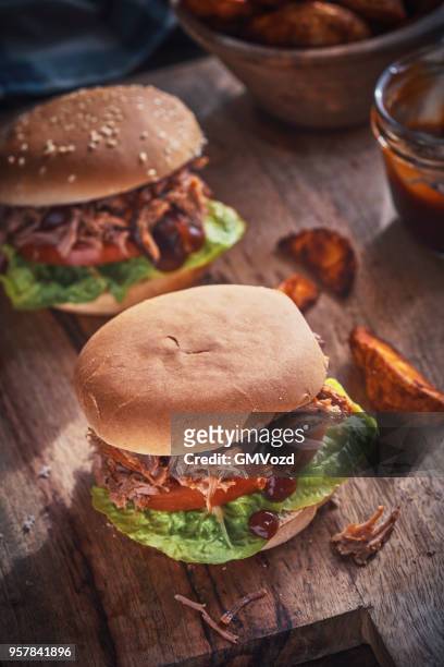 messy pulled pork burger with barbecue sauce and fresh salad - pickled pork stock pictures, royalty-free photos & images