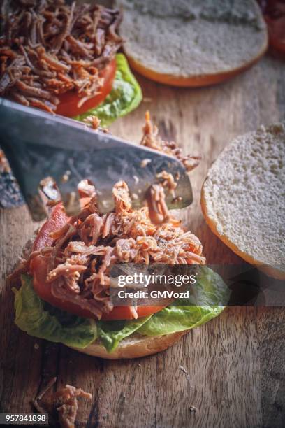 messy pulled pork burger with barbecue sauce and fresh salad - pickled pork stock pictures, royalty-free photos & images