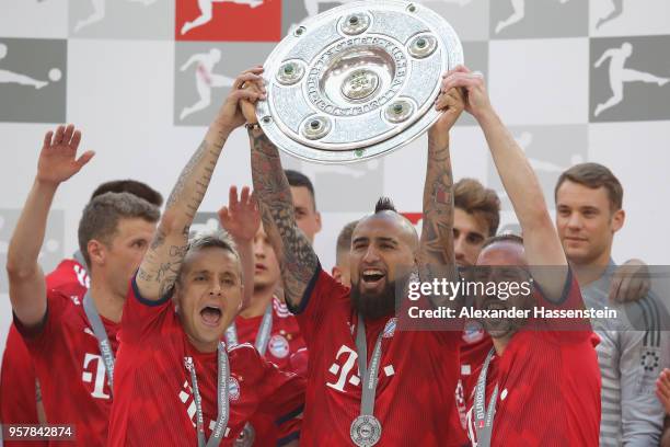 Rafinha of Bayern Muenchen lifts with his team mates Arturo Vidal and Franck Ribery the trophy in Celebration for winning the German Champiosnhip...