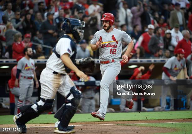 Paul DeJong of the St. Louis Cardinals scores ahead of the throw to Raffy Lopez of the San Diego Padres during the sixth inning of a baseball game at...