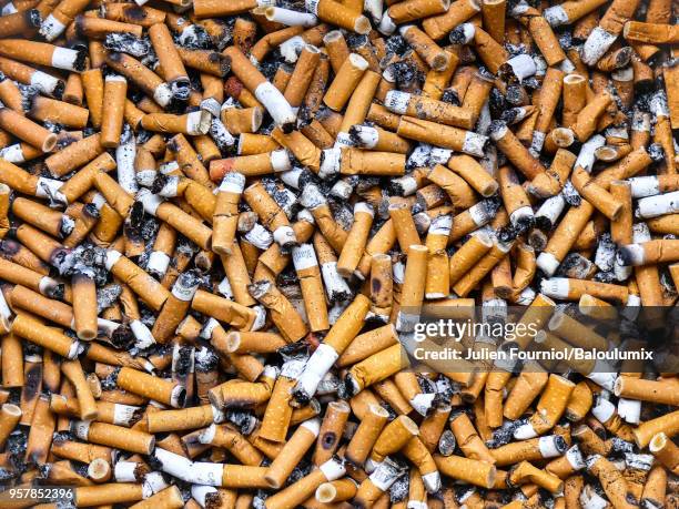 cigarette butts in a public ashtray. - aschenbecher stock-fotos und bilder