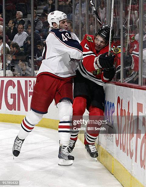 Jared Boll of the Columbus Blue Jackets pushes Brent Sopel into the boards on January 14, 2010 at the United Center in Chicago, Illinois.