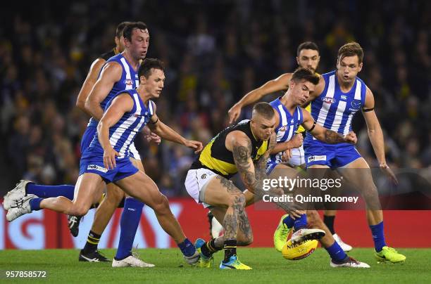 Dustin Martin of the Tigers is bumped by Jy Simpkin of the Kangaroos during the round eight AFL match between the North Melbourne Kangaroos and the...