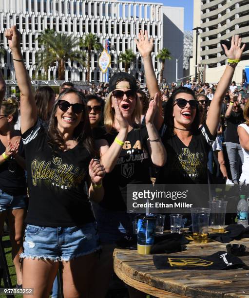 Fans cheer after watching singers perform the national anthems of the United States and Canada during a Vegas Golden Knights road game watch party at...