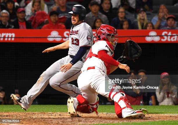 Mitch Garver of the Minnesota Twins is safe at the plate as he beats the throw to Rene Rivera of the Los Angeles Angels of Anaheim on a single by...