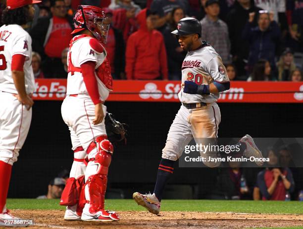 Noe Ramirez and Rene Rivera of the Los Angeles Angels of Anaheim look on as Eddie Rosario scores on a double by Mitch Garver of the Minnesota Twins...