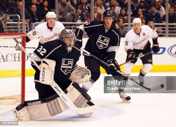 Jonathan Quick of the Los Angeles Kings makes a save in front of Rob Scuderi as Corey Perry and Ryan Getzlaf of the Anaheim Ducks skate in for a...