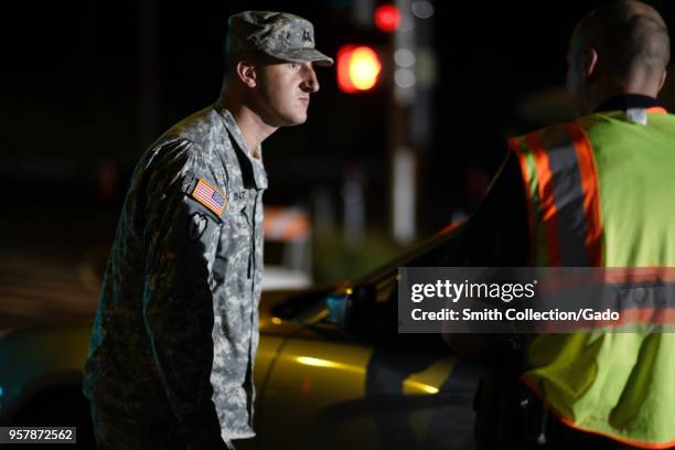 Hawaii Army National Guard Task Force Capt Brian Hunt speaking with local police officer at a traffic control point during a volcanic outbreak, Pahoa...