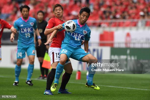 Kei Ikeda of Sagan Tosu and Kazuki Nagasawa of Urawa Red Diamonds compete for the ball during the J.League J1 match between Urawa Red Diamonds and...