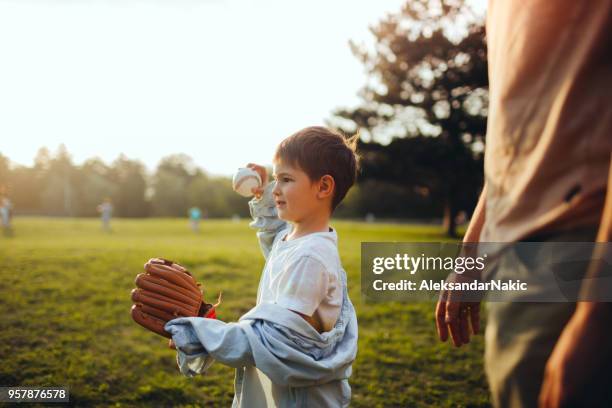 vader en zoon spelen inhalen die in het veld - boy throwing stockfoto's en -beelden