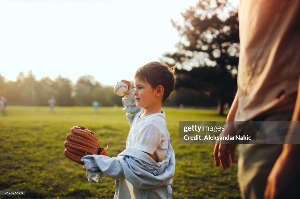 Father and son playing catch out in the field