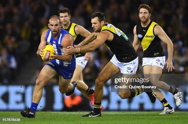 Ben Cunnington of the Kangaroos is tackled by Toby Nankervis of the Tigers during the round eight AFL match between the North Melbourne Kangaroos and...