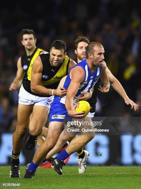 Ben Cunnington of the Kangaroos is tackled by Toby Nankervis of the Tigers during the round eight AFL match between the North Melbourne Kangaroos and...