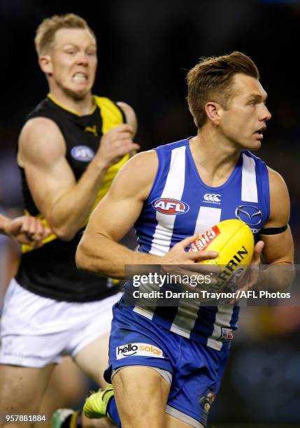 Shaun Higgins of the Kangaroos runs with the ball during the round eight AFL match between the North Melbourne Kangaroos and the Richmond Tigers at...