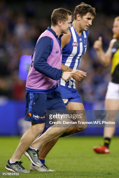 Jarrad Waite of the Kangaroos is helped off the ground by club trainers during the round eight AFL match between the North Melbourne Kangaroos and...