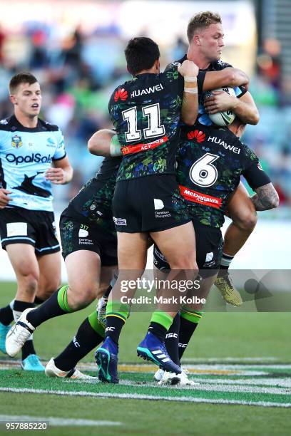 Matt Moylan of the Sharks is tackled during the round 10 NRL match between the Canberra Raiders and the Cronulla Sharks at GIO Stadium on May 13,...