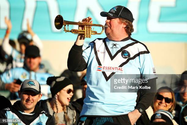 Sharks supporter in the crowd plays his trumpet during the round 10 NRL match between the Canberra Raiders and the Cronulla Sharks at GIO Stadium on...