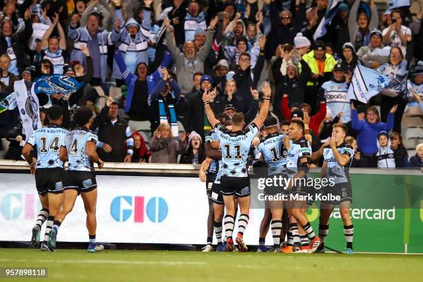 The Sharks celebrate with Sosaia Feki of the Sharks aftre he scored the try to seal their win during the round 10 NRL match between the Canberra...