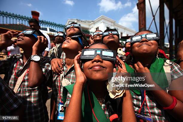 Indian people observe the rare Annular Solar Eclipse at the central stadium on January 15, 2010 in Thiruvananthapuram , Kerala, South India.This rare...