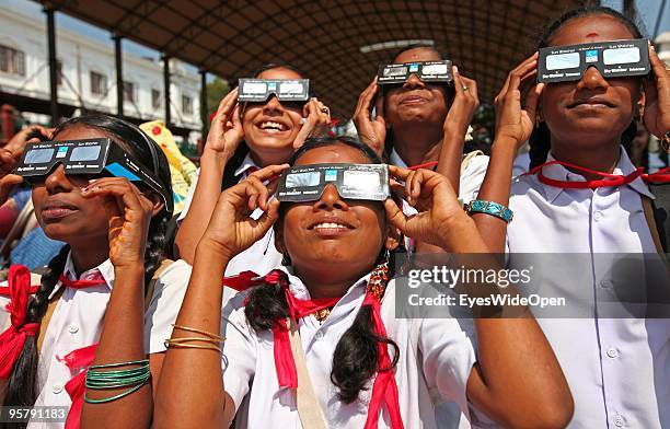 Indian people observe the rare Annular Solar Eclipse at the central stadium on January 15, 2010 in Thiruvananthapuram , Kerala, South India.This rare...