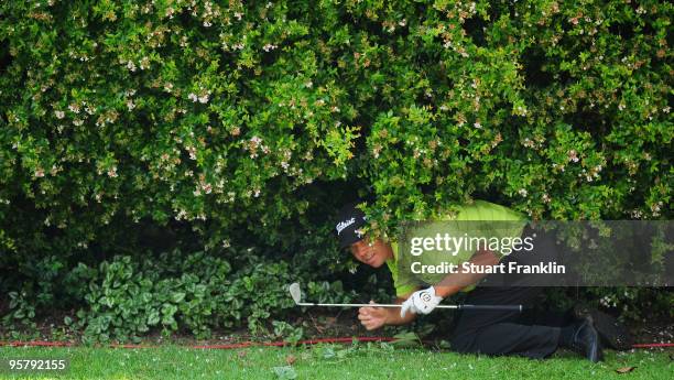 Keith Horne of South Africa plays a shot from under a bush on the 14th hole during the second round of the Joburg Open at Royal Johannesburg and...