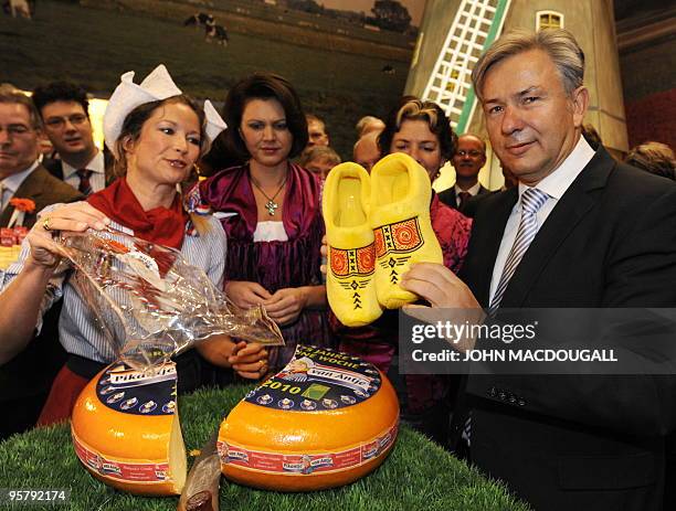 Berlin Mayor Klaus Wowereit displays a pair of clog "slippers" he received while visiting the dutch stand as Dutch Agriculture Minister Gerda Verburg...