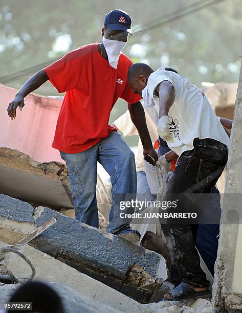 Locals take out a victim from under the destroyed Nursing School, in Port-au-Prince on January 14 following a devastating earthquake that rocked...