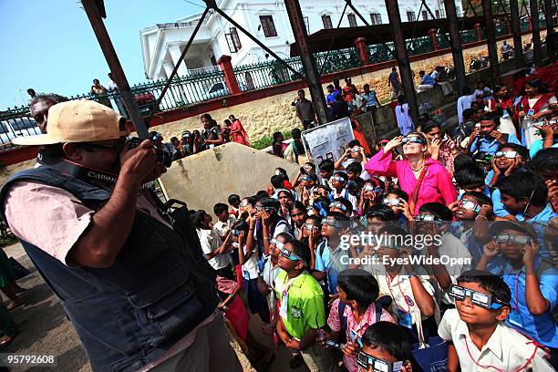 Indian media photographer take pictures of students and a tourist woman observing the rare Annular Solar Eclipse on January 15, 2010 at the central...