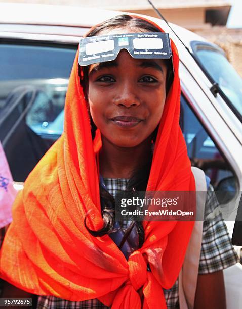 Indian girl observes the rare Annular Solar Eclipse on January 15, 2010 at the central stadium of Thiruvananthapuram in Kerala, South India.This rare...