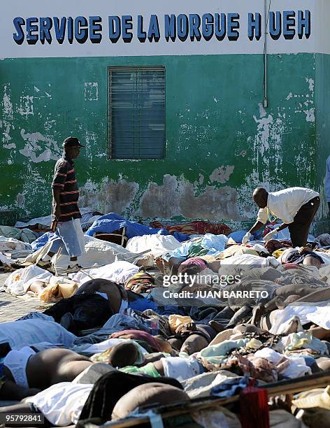 Worker of the morgue injects the bodies of victims to retard its putrefaction, outside the morgue in Port-au-Prince on January 14 following a...